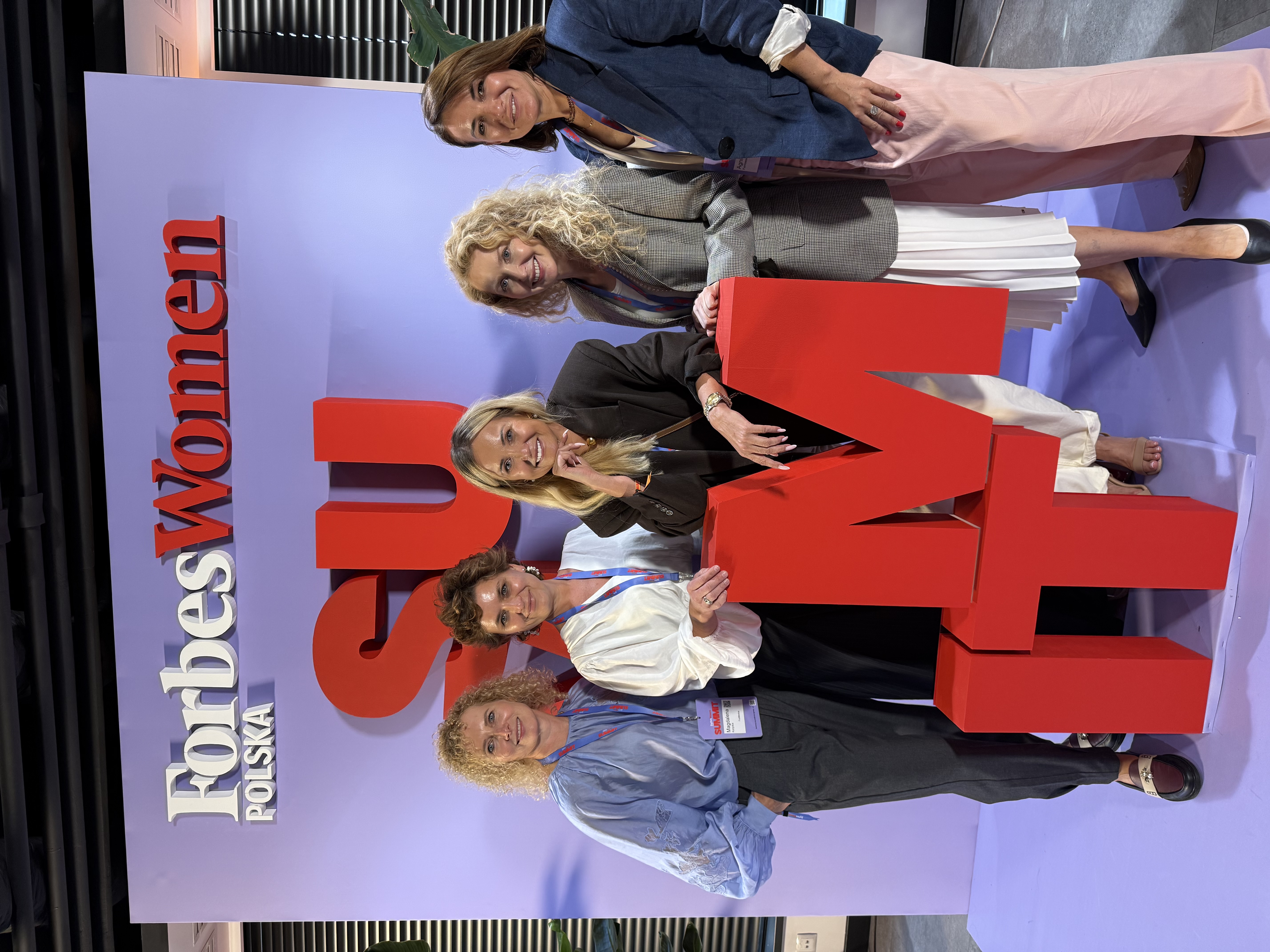 Paulina Kruk with other participants in front of the Forbes Women Polska backdrop at the first Forbes Women Summit in Warsaw
